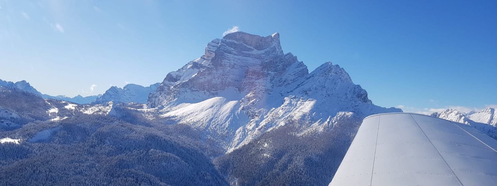 Un aeroplano della scuola in volo fra le Dolomiti, con il Pelmo sotto l&rsquo;ala