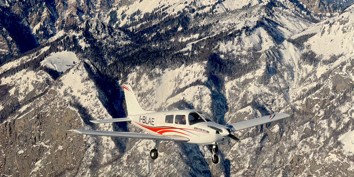 Il Piper PA-28 I-BLAE in volo sopra le montagne innevate